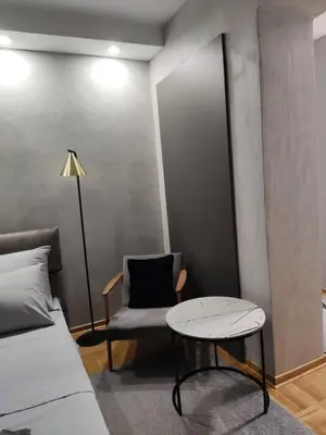 a room with a bed and a chair and a table at KaLuMa in Belgrade