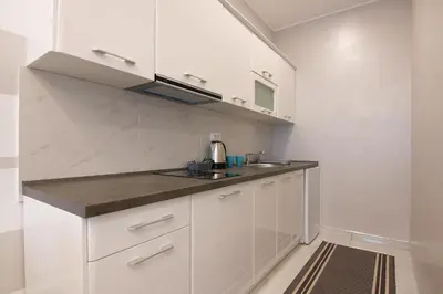 a kitchen with white cabinets and a sink at Jana apartmani in Novi Grad