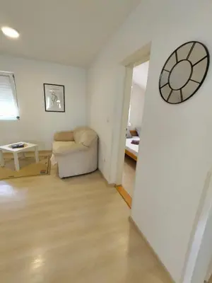 a living room with a couch and a clock on the wall at A1 - Airport Belgrade Apartment in Belgrade