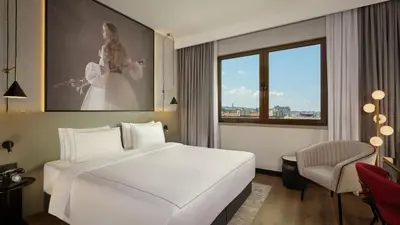 a bedroom with a large white bed and a window at Radisson RED Belgrade in Belgrade