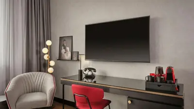 a room with a desk with a television and a chair at Radisson RED Belgrade in Belgrade