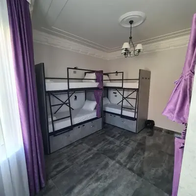 two bunk beds in a room with purple curtains at Up Hostel in Belgrade