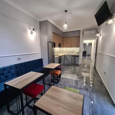 a restaurant with tables and chairs and a kitchen at Up Hostel in Belgrade