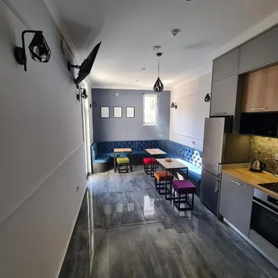 a kitchen with a table and chairs in a room at Up Hostel in Belgrade