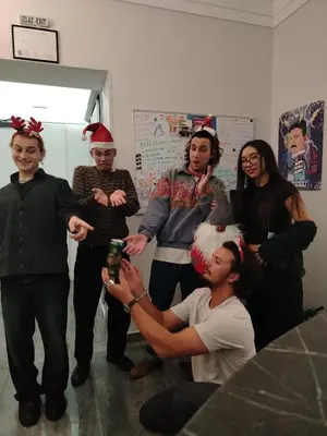 a group of people wearing christmas hats posing for a picture at Up Hostel in Belgrade