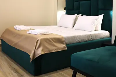 a bed with a blue headboard with two towels on it at Up Apartments in Belgrade