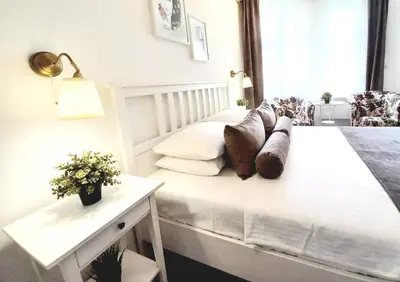 a bedroom with a white bed with pillows on it at GENIUS STUDIO in Belgrade