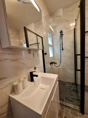 a white bathroom with a sink and a shower at GENIUS STUDIO in Belgrade