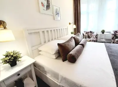 a bedroom with a white bed with pillows on it at GENIUS STUDIO in Belgrade