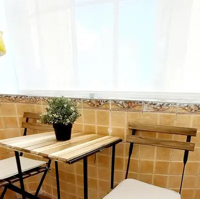 a table with two chairs and a potted plant on it at GENIUS STUDIO in Belgrade