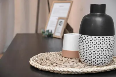 a black bottle sitting on a table next to a cup at Apartment GREEN in Belgrade