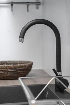 a kitchen sink with a black faucet and a basket at Apartment GREEN in Belgrade