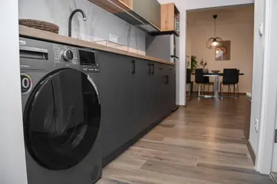 a kitchen with a black washing machine in a room at Apartment GREEN in Belgrade