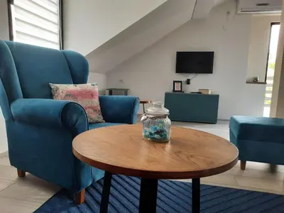 a living room with two blue chairs and a table at Galerija Park 2 in Arandjelovac