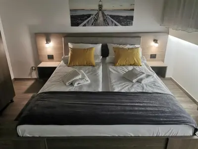 a bedroom with a large bed with yellow pillows at Apartman PAVLOVIC 1 in Dedinje