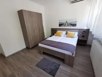 a bedroom with a large bed with yellow pillows at Apartman PAVLOVIC 1 in Dedinje