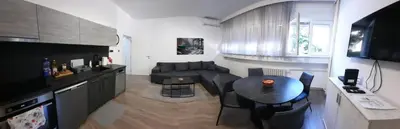 a living room with a table and a couch at Apartman PAVLOVIC 1 in Dedinje
