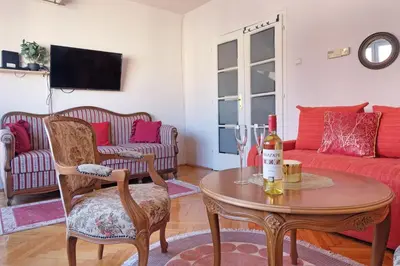 a living room with a table with a bottle of wine at Windows City Apartment in Belgrade