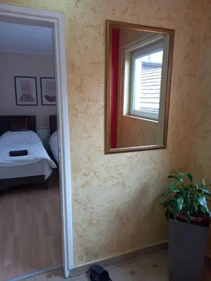 a mirror on a wall next to a bedroom at LEDA Apartmani in Smederevo