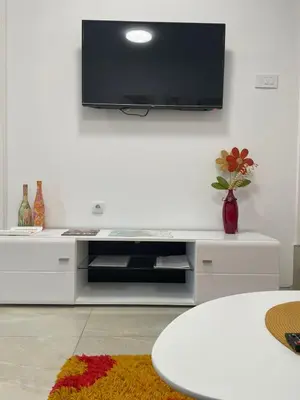 a living room with a tv on a wall at LEDA Apartmani in Smederevo