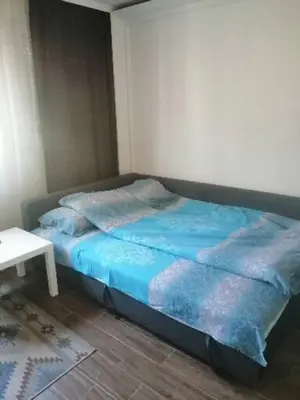 a bed with blue sheets in a room with a table at Caviar in Belgrade