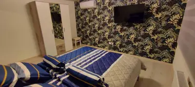 a bedroom with a bed and a tv on the wall at Apartman Green Garden Aranđelovac in Arandjelovac