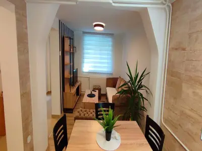 a living room with a table and a couch at Apartman Green Garden Aranđelovac in Arandjelovac