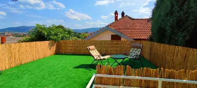 two chairs and a table on a green lawn at Apartman Green Garden Aranđelovac in Arandjelovac