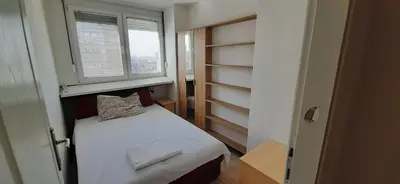 a small bedroom with a bed and a window at Apartman Šumice in Vračar (historical)