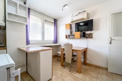 a small kitchen with a desk and a table in a room at Apartman Šumice in Vračar (historical)