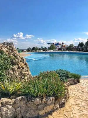 a large swimming pool with blue water and plants at S Club Resort Hotel Aqua Park and Spa in Belgrade