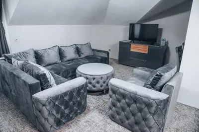 a living room with couches and a table and a tv at S Club Resort Hotel Aqua Park and Spa in Belgrade