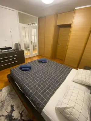 a bedroom with a large bed with blue pillows on it at Lord's Apartment in Belgrade