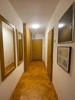 a hallway with wood floors and a door in a room at Lord's Apartment in Belgrade