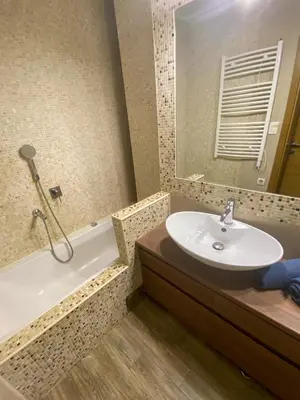 a bathroom with a sink and a tub and a mirror at Lord's Apartment in Belgrade