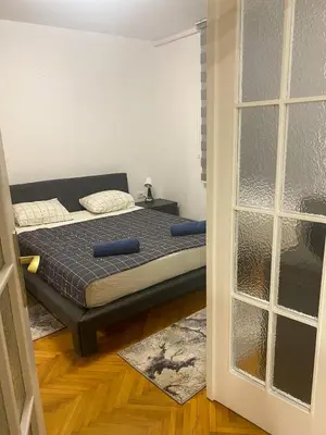 a bedroom with a bed and a window at Lord's Apartment in Belgrade