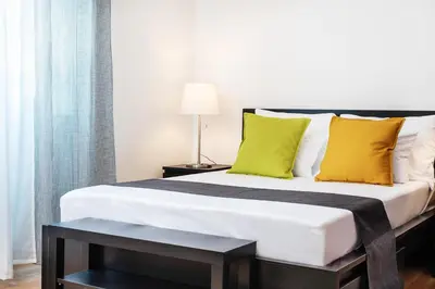 a bedroom with a large bed with yellow pillows at Studio apartment Financial Park Belgrade in Belgrade