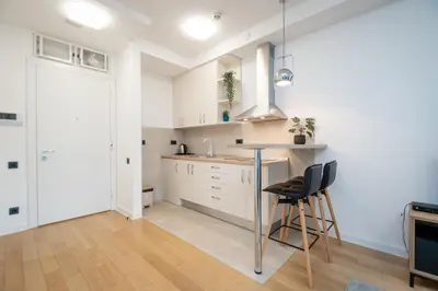 a kitchen with white cabinets and a table and chairs at Apartment Atrium- A blok in Novi Beograd