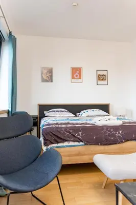 a bedroom with a bed and two chairs at Apartment Atrium- A blok in Novi Beograd