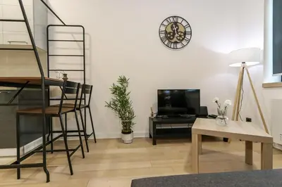 a living room with a ladder and a tv and a table at Apartment Atrium- A blok in Novi Beograd