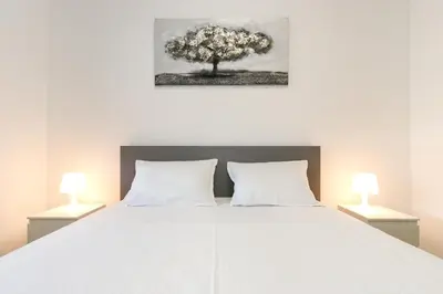 a bedroom with a large white bed with two lamps at Apartment Atrium- A blok in Novi Beograd