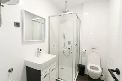 a white bathroom with a shower and a toilet at Apartment Atrium- A blok in Novi Beograd