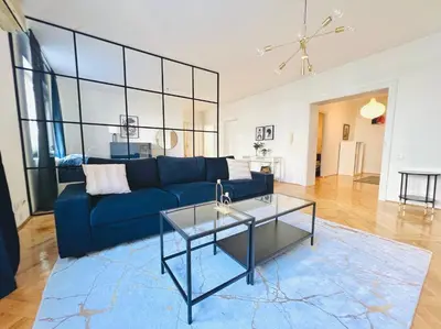 a living room with a blue couch and a glass table at Alva Lux Apartment in Belgrade