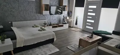 a bedroom with a bed and a tv on a wall at Apartman Bajka in Ruma