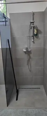 a shower with a glass door in a bathroom at Apartman Bajka in Ruma