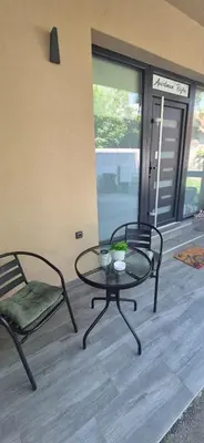 a patio with a table and two chairs and a door at Apartman Bajka in Ruma