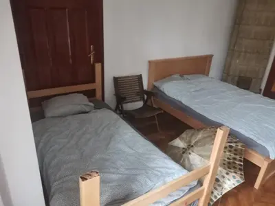 a bedroom with two beds and a chair at Cozy place 1 in Belgrade