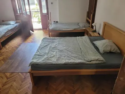 two beds in a room with wooden floors at Cozy place 1 in Belgrade