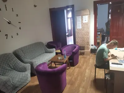 a man sitting at a desk in a room with purple chairs at Cozy place 1 in Belgrade