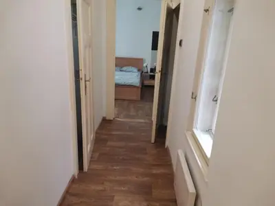 a hallway with a room with a bed and a wooden floor at Cozy place 1 in Belgrade